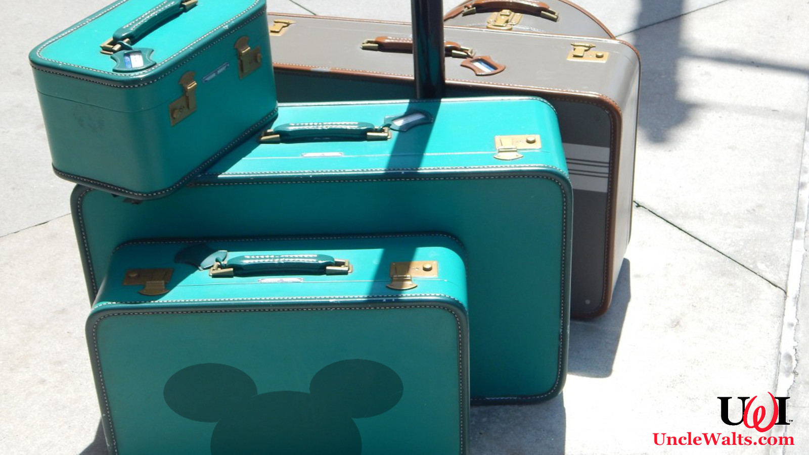 Some suitcases, one of which has a Mickey silhouette on it.